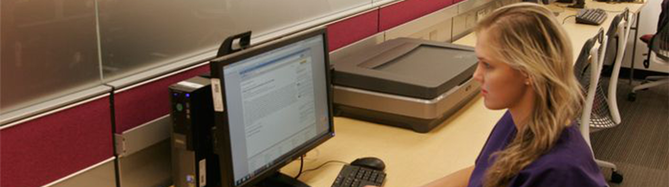 A student at work on a computer in the Multimedia Collaboration room in Tompkins-McCaw Library.