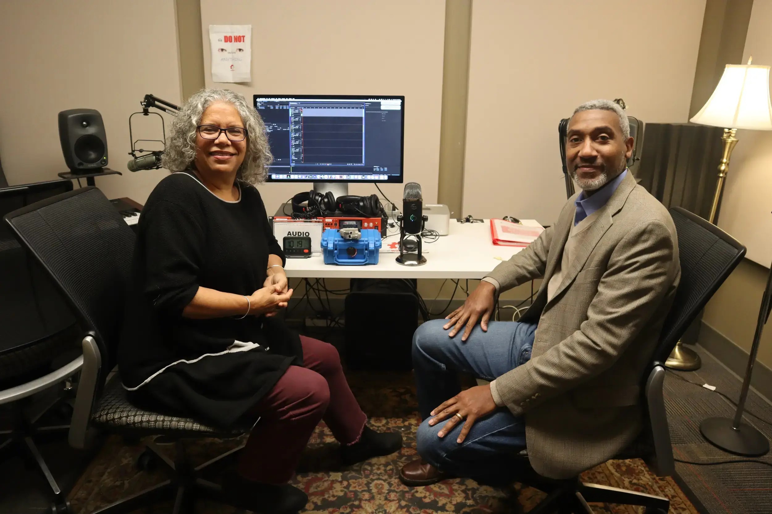 Two people sitting in a audio studio