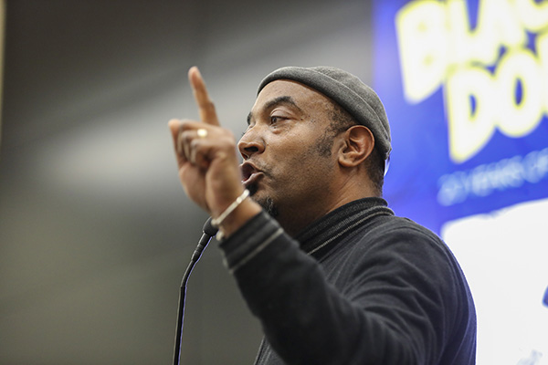 Keith Knight speaking in front of a screen at the 18th annual Black History Month lecture