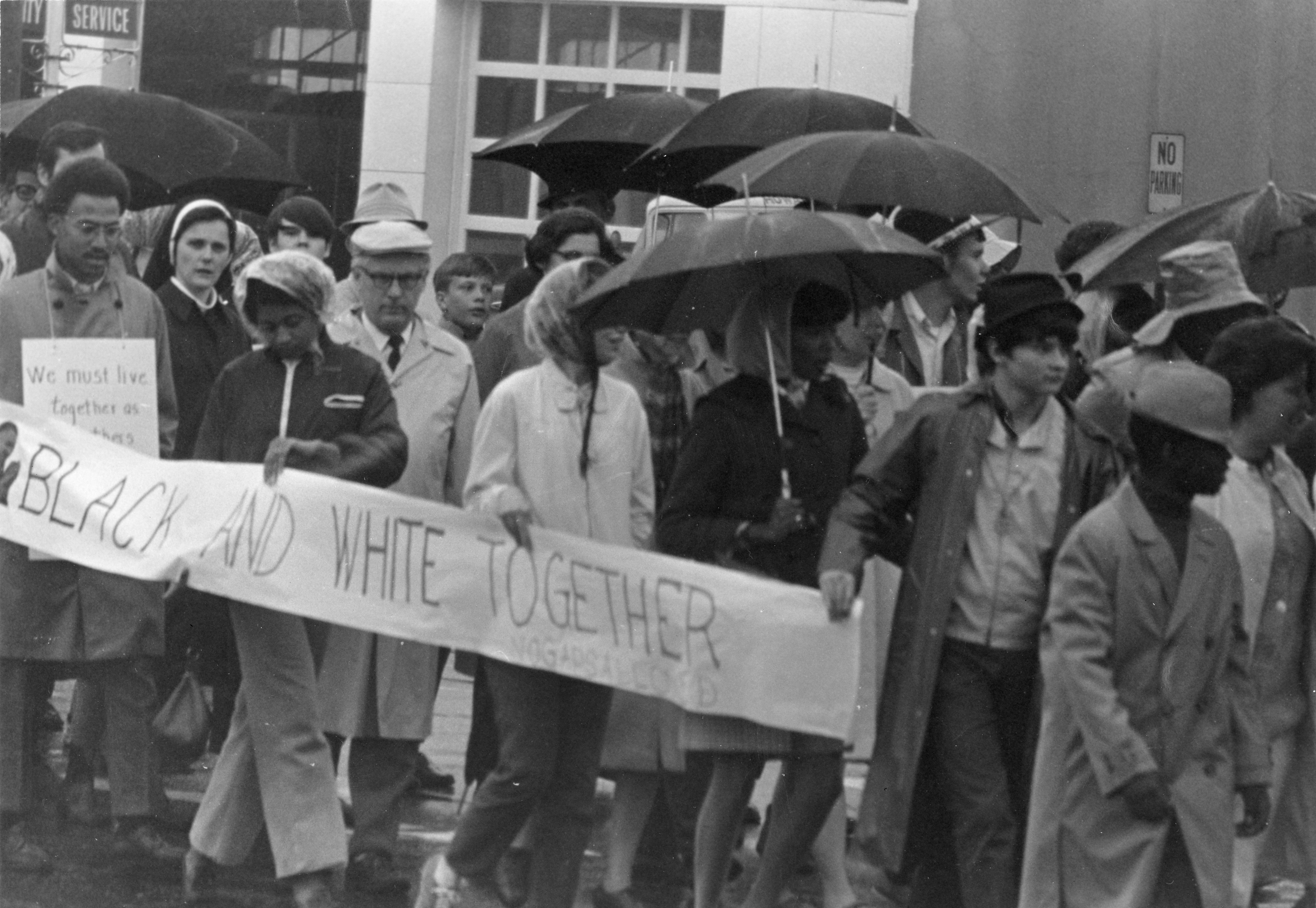 People walk in a Martin Luther King Jr. memorial parade in the rain.