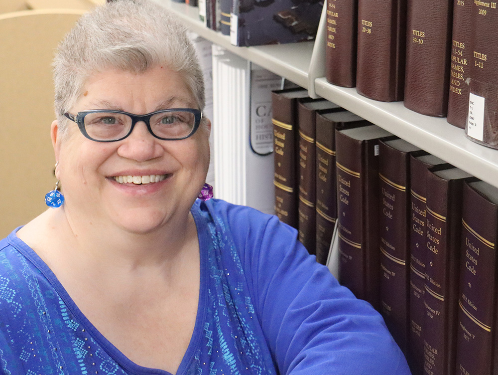 Nia Rodgers in front of books in James Branch Cabell Library.