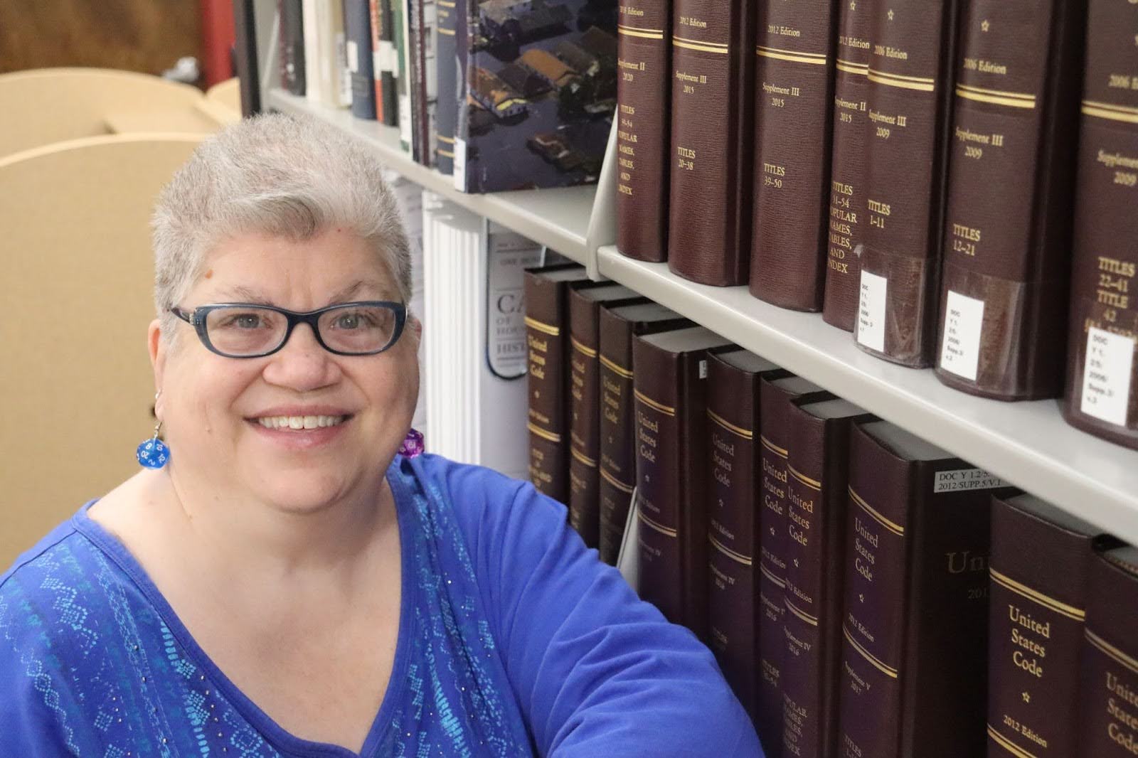 Nia Rodgers standing in front of books