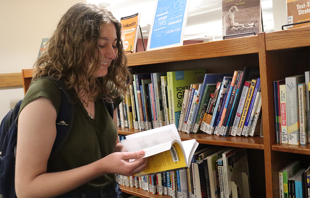 Josie Krasny browses books on the Student Success shelf at James Branch Cabell Library.