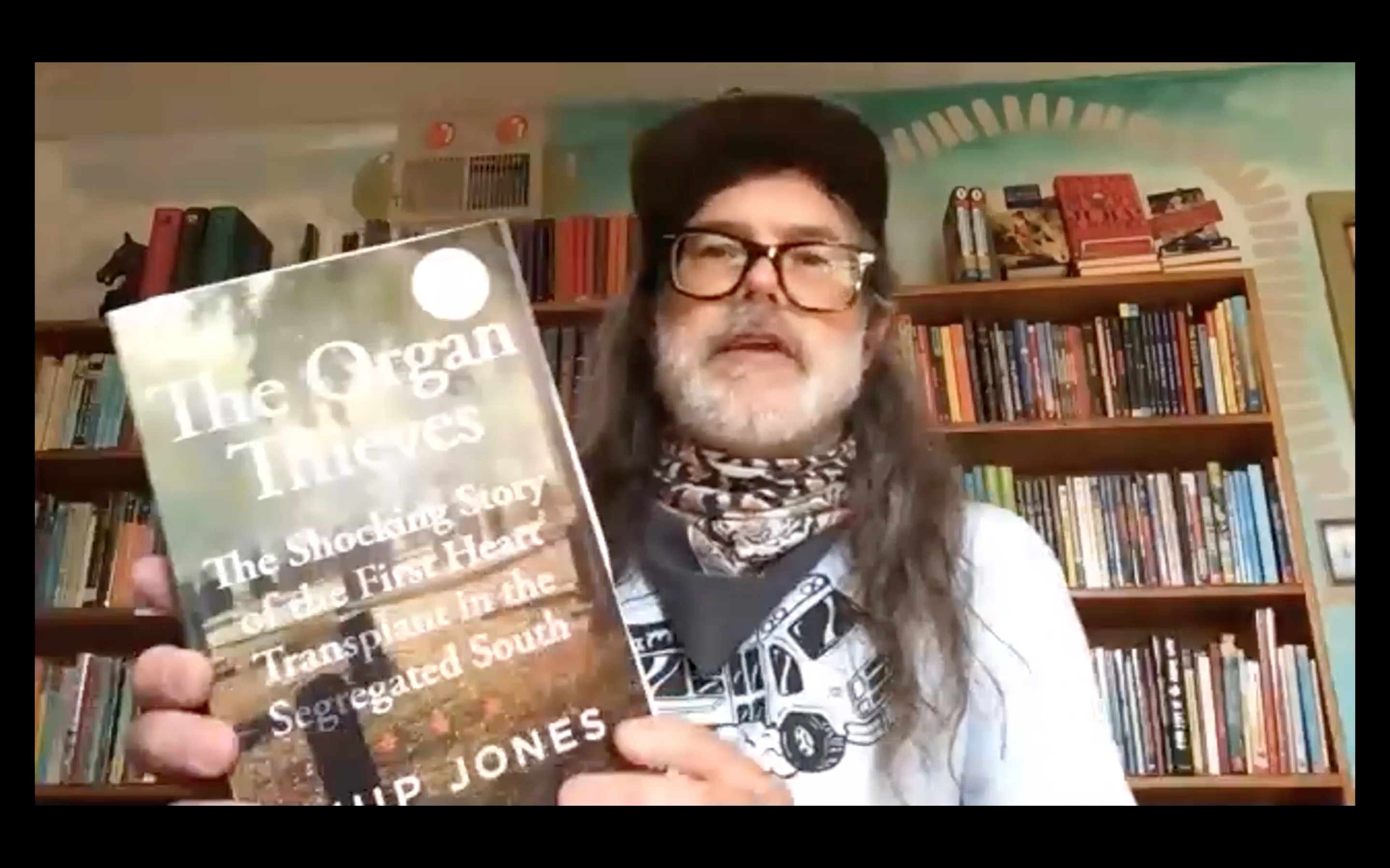 Ward Tefft, owner of Chop Suey Books, holding a copy of the book Organ Thieves during a session of VCU Libraries Community Zooms