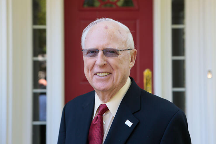 photo of Jack Hansan standing in front of a red door