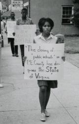 Protester carrying closing of Schools sign